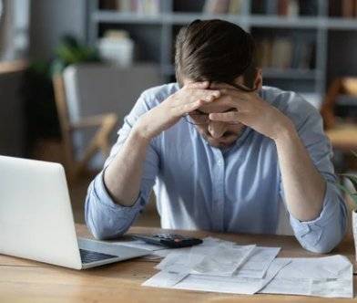 Parent reviewing bills and insurance paperwork at a kitchen table